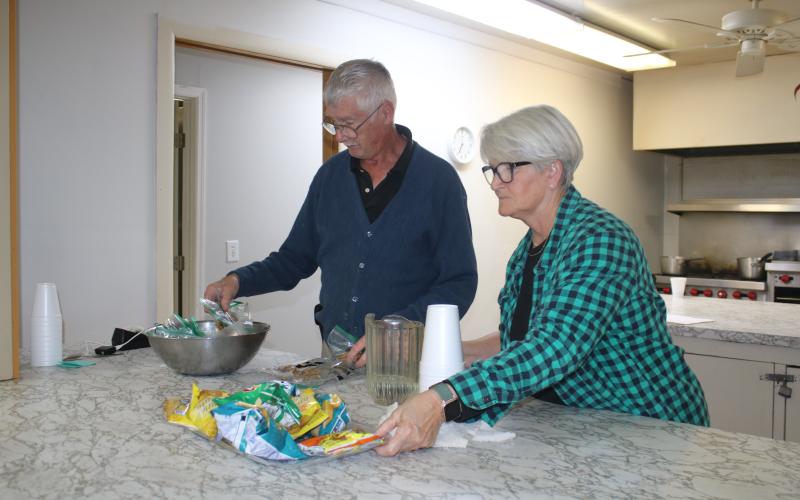 Bob Smith and Jeannie McGalliard, Parkview Baptist Church cold weather shelter volunteers, put out snacks for clients utilizing the facility on Tuesday night. (TONY BRITT/Lake City Reporter)