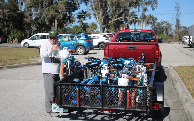 Mike Kelley, Suwannee Bicycle Association vice president, unloads a child’s bike from a trailer on Wednesday afternoon. (TONY BRITT/Lake City Reporter)