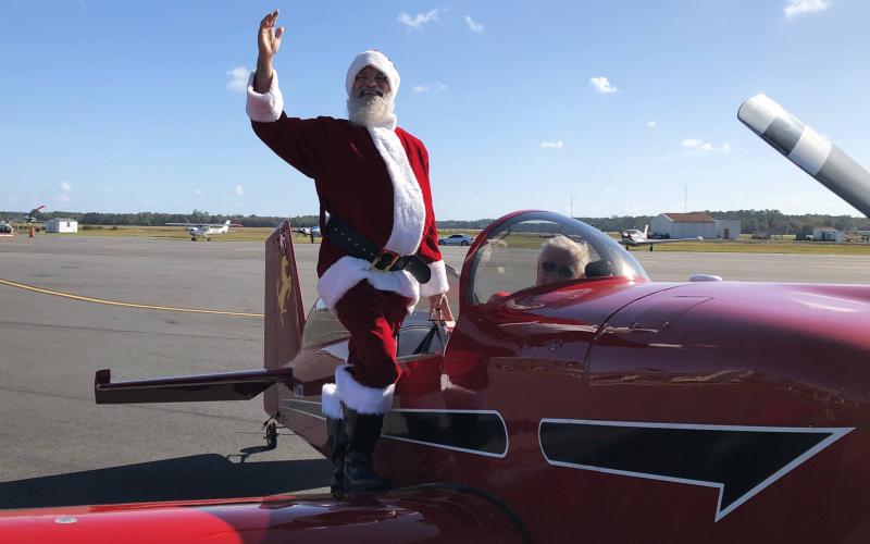 Santa Claus waves after landing in an airplane Saturday at the Lake City Gateway Airport for an event for the local Toys for Tots chapters. (COURTESY)