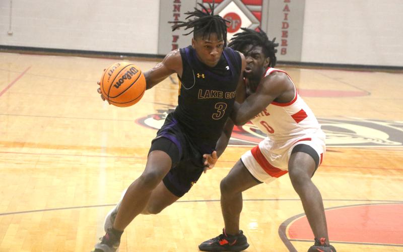 Columbia guard Zamarion Jones drives past Santa Fe’s NyShaun Jenkins on Friday night. (MORGAN MCMULLEN/Lake City Reporter)