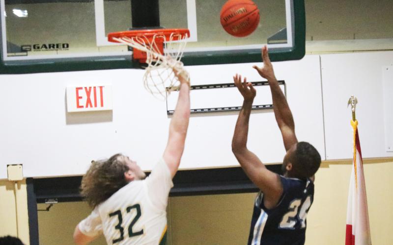 Santa Fe forward Makye Boles makes a putback at the buzzer over FGC forward Axel Holmquist on Thursday. (JORDAN KROEGER/Lake City Reporter)