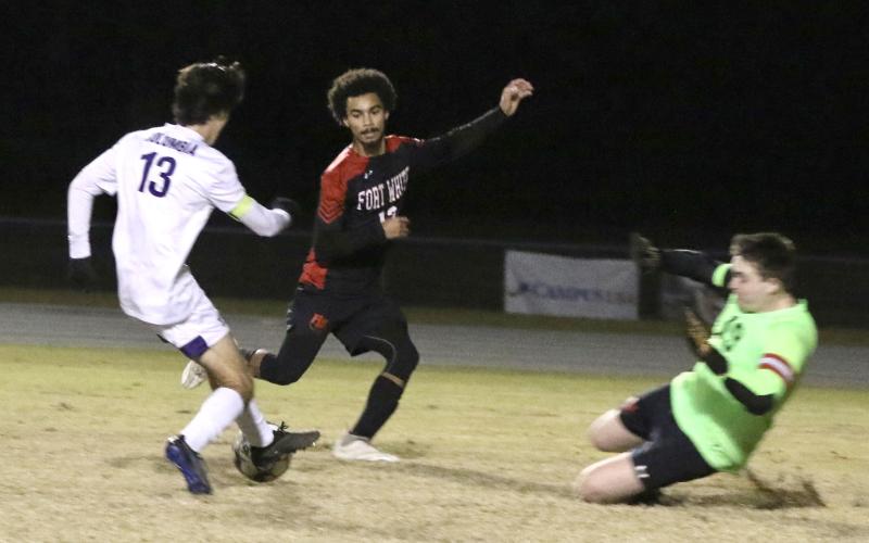 Columbia’s Bergen Cobb (13) dribbles into the box against Fort White’s Jared Hopkins and Colt Patterson during Thursday’s game. (MORGAN MCMULLEN/Lake City Reporter)
