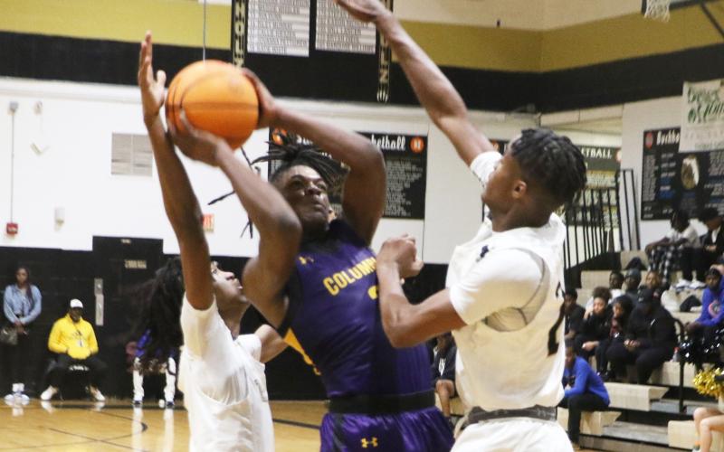 Columbia guard Zamarion Jones drives to the basket between two Buchholz defenders on Tuesday night. (MORGAN MCMULLEN/Lake City Reporter)