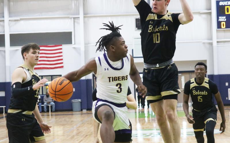 Columbia guard Zamarion Jones passes around Buchholz forward Gabe Thompson during the Hitchcock’s Challenge on Friday. (JORDAN KROEGER/Lake City Reporter)