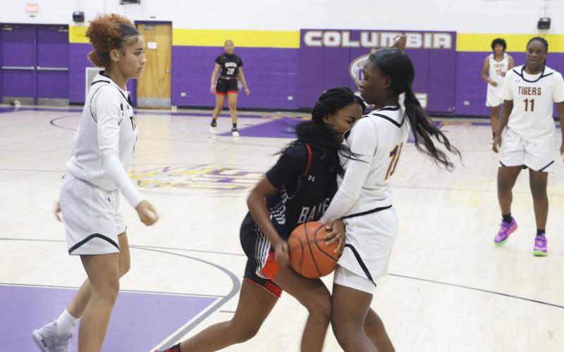 Columbia guard Ayesha Broxey (right) boxes in a Baker County dribbler in the backcourt as guard Mariah Cox comes over to help during Tuesday’s game. (MORGAN MCMULLEN/Lake City Reporter)
