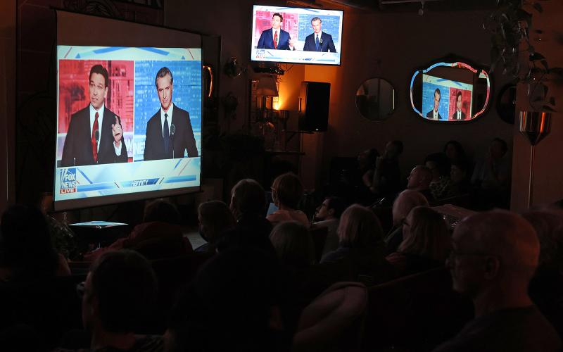 People watch a debate between California Gov. Gavin Newsom and Florida Gov. Ron DeSantis during a watch party at Manny’s on Thursday in San Francisco. Newsom and DeSantis were hosted by Sean Hannity on Fox. (JUSTIN SULLIVAN/Getty Images/TNS)
