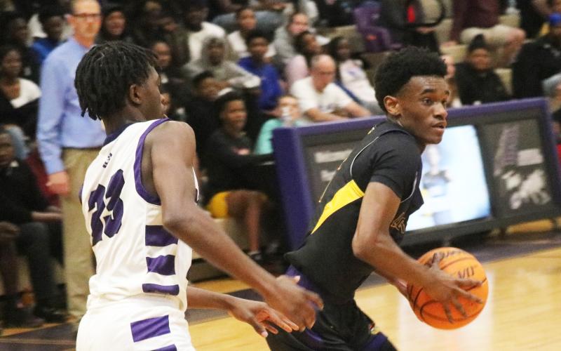 Columbia guard Bobby Wilson looks for a driving lane while being defended by Gainesville guard Willie Brooks on Tuesday. (JORDAN KROEGER/Lake City Reporter)