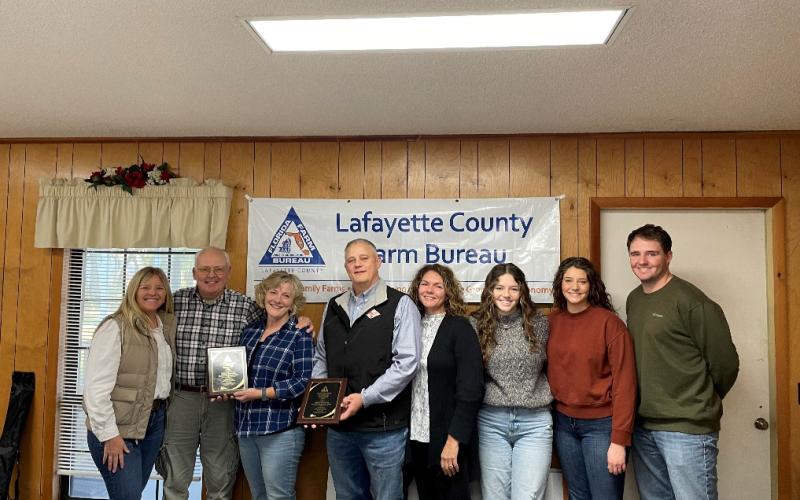 Gary Keyes and Johan Heijkoop and their families were honored as the Lafayette County Farm Bureau Farm Family of the Year at its Dec. 11 meeting. Pictured are Lafayette County Extension Ag Agent Emily Beach (from left), Gary Keyes, Kathy Keyes, Johan Heijkoop, Trisha Heijkoop, Jaylee Heijkoop, Julia Heijkoop and Jozef Heijkoop. Not pictured is Johanna Heijkoop. (COURTESY)