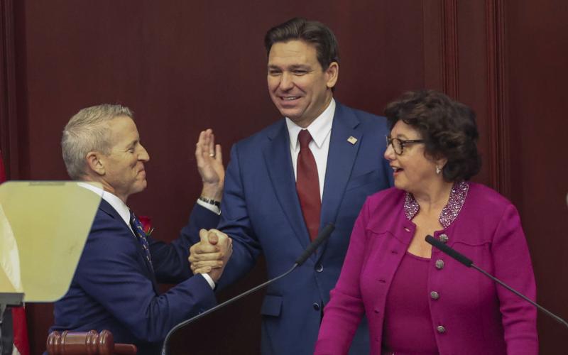 Florida Gov. Ron DeSantis is welcomed to a joint session of the Senate and House of Representatives by House Speaker Paul Renner, left, and Florida Senate President Kathleen Passidomo, right, to give his State of the State address in Tallahassee on Tuesday. (GARY MCCULLOUGH/Associated Press)