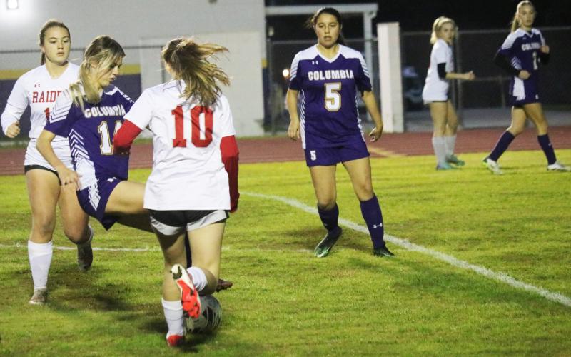 Columbia's Mia Brasel dribbles between Santa Fe defenders on Thursday night. (JORDAN KROEGER/Lake City Reporter)