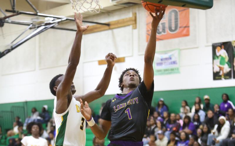 Columbia guard Marlin Haywood makes a layup while being defended by Suwannee guard MJ Rossin on Tuesday night. (PAUL BUCHANAN/Special to the Reporter)