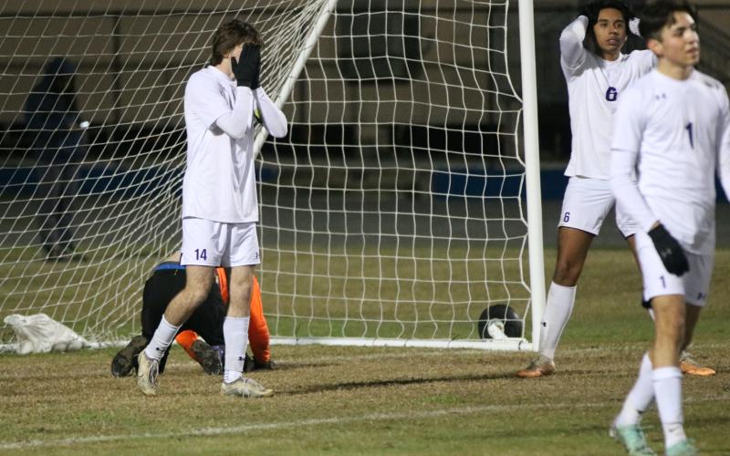Columbia defenders Bobby Shotwell (14), Eduardo Morales (6) and Jonathan Pineda (1) react to a Clay goal as goalkeeper Augustus Mock sits on his knees in the goal during Monday's District 2-5A semifinal. (JORDAN KROEGER/Lake City Reporter)