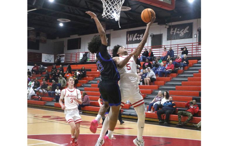 Fort White guard Tafari Moe goes for a layup against Newberry's Kai Washington during Thursday's game. (MORGAN MCMULLEN/Lake City Reporter)