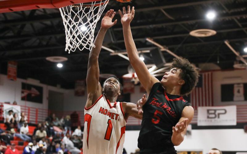 Fort White guard Tafari Moe gets off a shot while being defended by Hawthorne guard CJ Ingram during Thursday's District 6-1A semifinal. (BRENT KUYKENDALL/Lake City Reporter)
