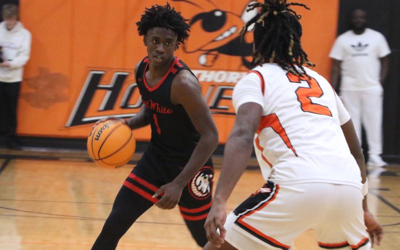 Fort White guard Jayden Jackson sizes up Hawthorne's Caleb Rollerson in the first half of Thursday's Region 3-1A semifinal. (MORGAN MCMULLEN/Lake City Reporter)