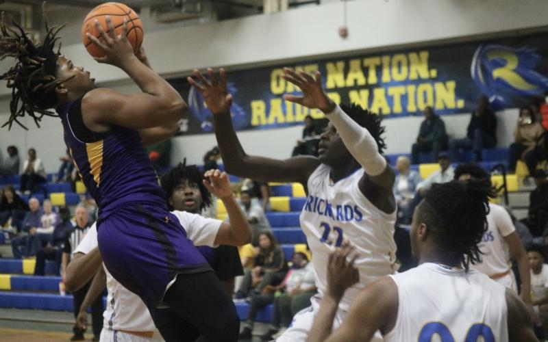 Columbia forward Jalen Gaskins tries to get a shot up over Rickards forward Tarek Caesor during Thursday’s Region 1-5A quarterfinal. (JORDAN KROEGER/Lake City Reporter)