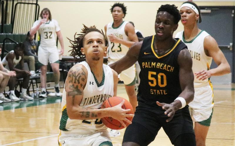 FGC guard Jazan Johnson drives past Palm Beach State guard Devontre Chaney for a basket on Jan. 17. (JORDAN KROEGER/Lake City Reporter)