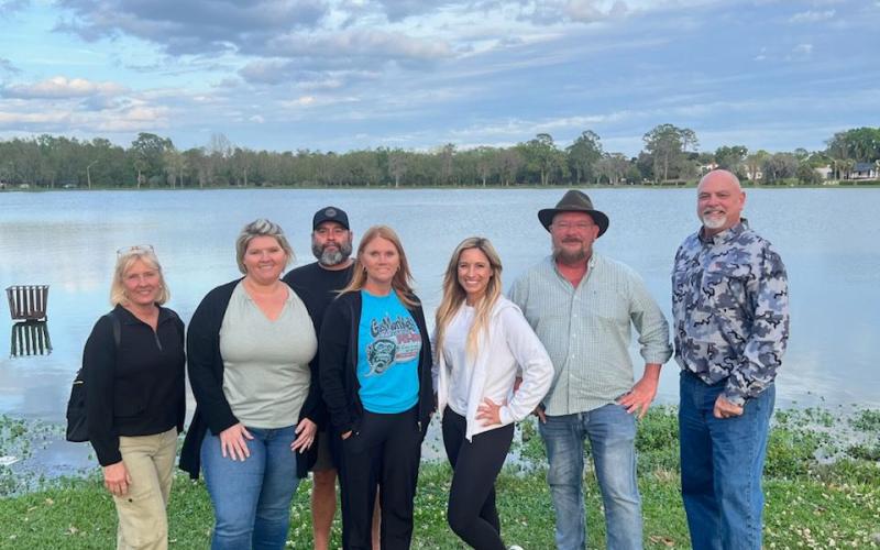 DeSoto Derby Canoe Race committee members Dana Solenski (from left), Brandy Meeks, Troy Markham, Lindsey Markham, Rosy Sparks, Chris Samson and Jerry Solenski, stand on the banks of Lake DeSoto. Elks Lodge #893 is hosting a canoe race this weekend on the lake as a fundraiser. (COURTESY)