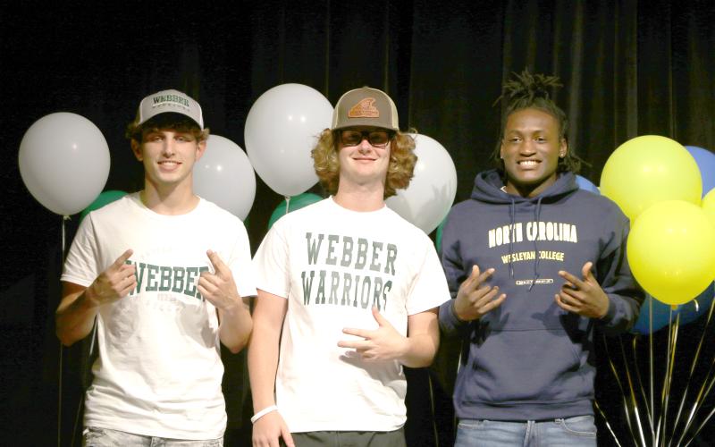 Fort White soccer players Gavin Heaton (left) and Connor Bass (right) signed their letters of intent with Webber International, while football player Maliki Clark (right) signed with North Carolina Wesleyan on Thursday. (MORGAN MCMULLEN/Lake City Reporter)
