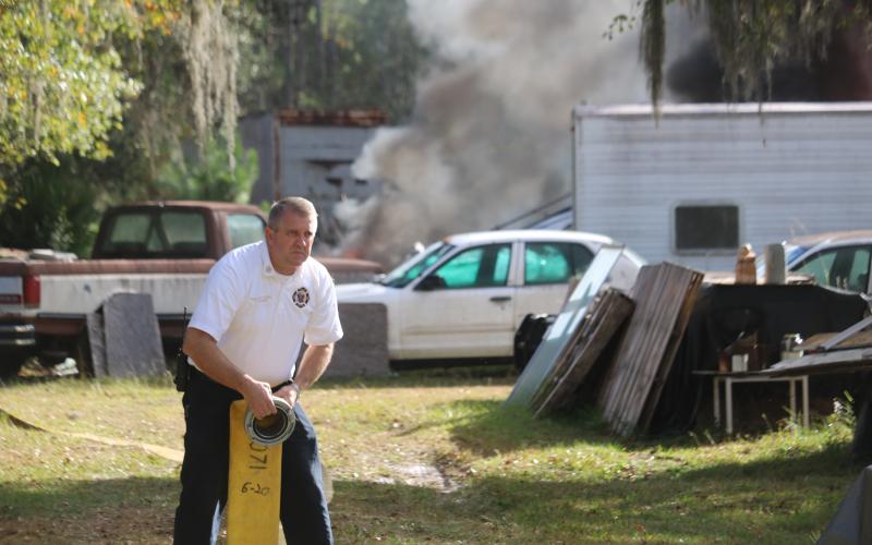 Lake City Assistant Fire Chief Dwight Boozer works with a hose at a fire. Boozer passed away Wednesday night after a battle with cancer. (FILE)