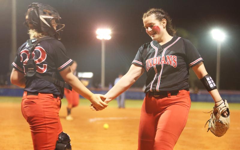 Fort White catcher Chloe Kirby (left) shakes hands with pitcher Kadence Compton (right) after the final out of the Indians’ win over Branford on March 1. (PAUL BUCHANAN/Special to the Reporter)