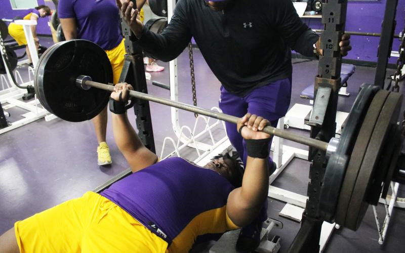 Columbia lifter Chase Johnson performs the bench press while head coach Brian Allen spots him during Wednesday’s meet against Madison County. (JORDAN KROEGER/Lake City Reporter)