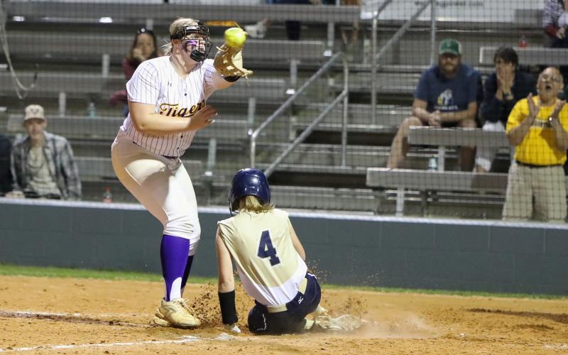 University Christian second baseman Alyssa Smith scores on a passed ball ahead of a throw to Columbia pitcher Josie Raulerson on Friday night. (BRENT KUYKENDALL/Lake City Reporter)