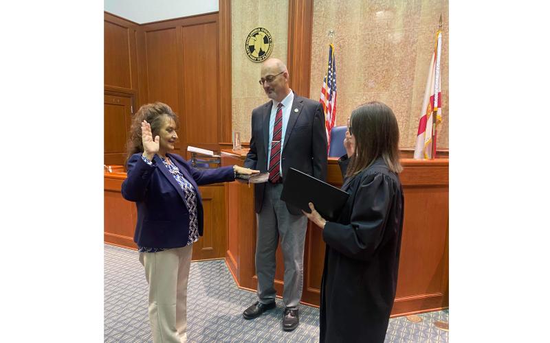 Tina Siefert (left) is sworn in as the Third Judicial Circuit’s new General Magistrate by Chief Judge Melissa Olin as Seifert’s fiancee John Blanchard holds the Bible during the private swearing-in ceremony Friday in the Columbia County Courthouse. (COURTESY)