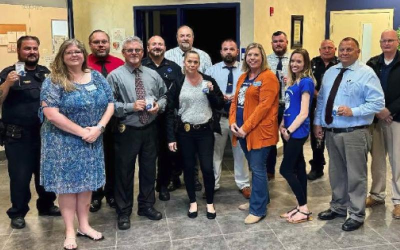 Members of the Lake City Police Department display their blue badges donated by the UF Child Advocacy Center to wear for Child Abuse Prevention Month. (COURTESY)