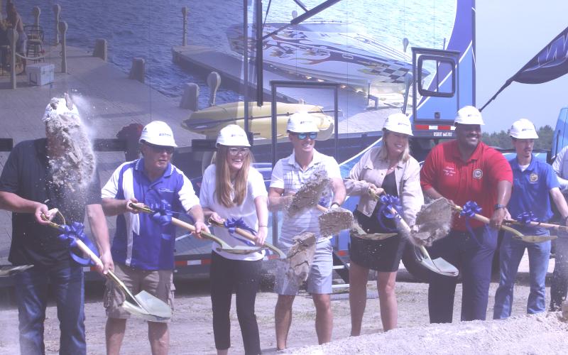 Wave Armor owner Rick Johanneck (second from left) and President Jennifer Johanneck-Eystad (third from left) toss shovels of dirt along with fellow Wave Armor representatives and Florida State Senator Corey Simon (right) during a groundbreaking ceremony Tuesday in Suwannee County. (JAMIE WACHTER/Lake City Reporter)