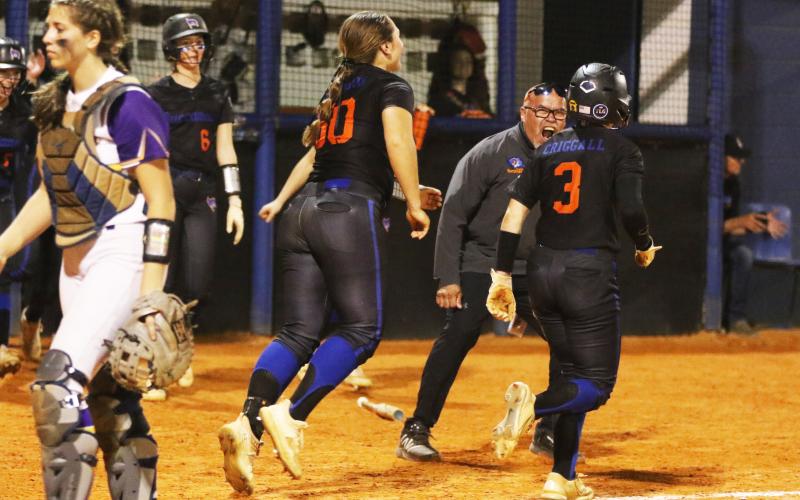 Branford coach Oscar Saavedra celebrates with Cloey Criggall after she scored the game-winning run against Bell on Friday. (MORGAN MCMULLEN/Lake City Reporter)