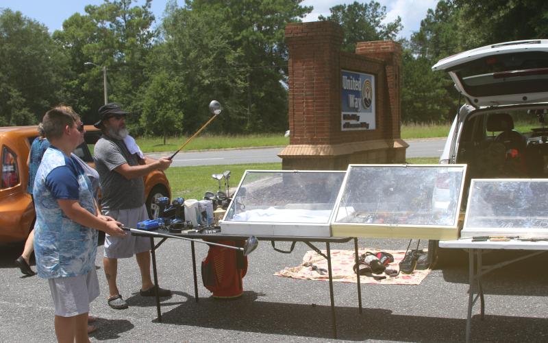 Some shoppers check out golf clubs at a previous United Way of Suwannee Valley community yard sale. (FILE)