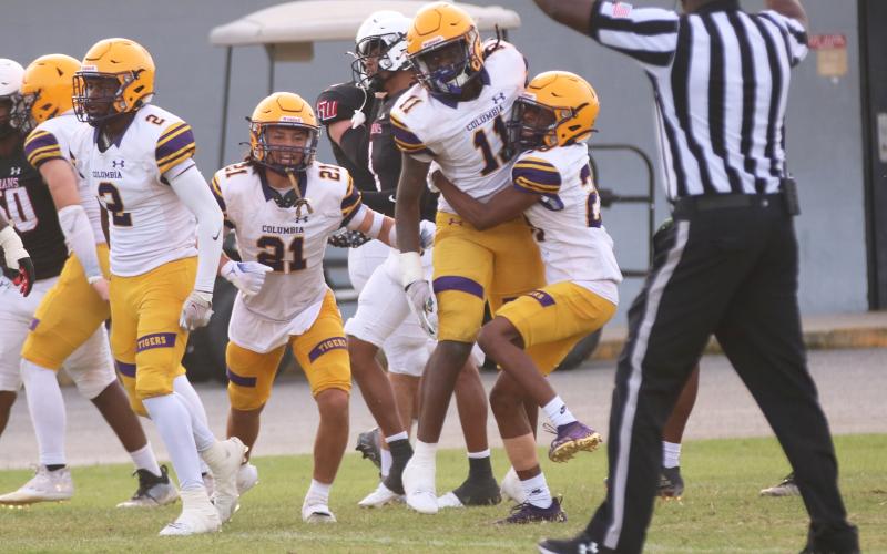 Columbia linebacker Dajon Brown celebrates with defensive backs Julian De La Cruz (21) and Mekah Combs-Turner (right) after his interception during Friday’s spring game against Fort White. (JORDAN KROEGER/Lake City Reporter)