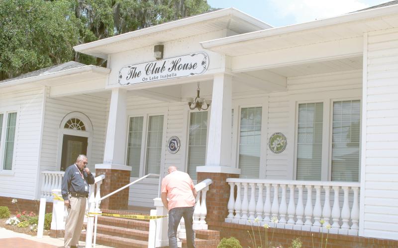 David Young and Marshall Sova with the City of Lake City cardon off The Club House on Lake Isabella after closing the building Wednesday due to broken girders and trusses in the building’s attic. (TONY BRITT/Lake City Reporter)