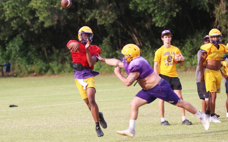 Columbia quarterback Xavier Collins throws a pass under pressure from defensive lineman Caden Bolstein during practice on May 1. (JORDAN KROEGER/Lake City Reporter)