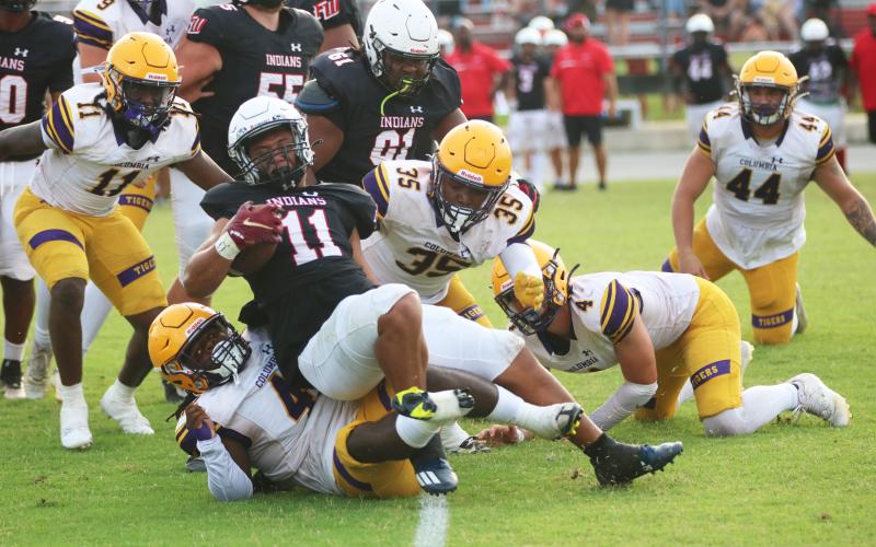 Fort White running back Lecosta Byrd is tackled by Columbia defensive lineman Terry Henry during Friday’s spring game. (JORDAN KROEGER/Lake City Reporter)