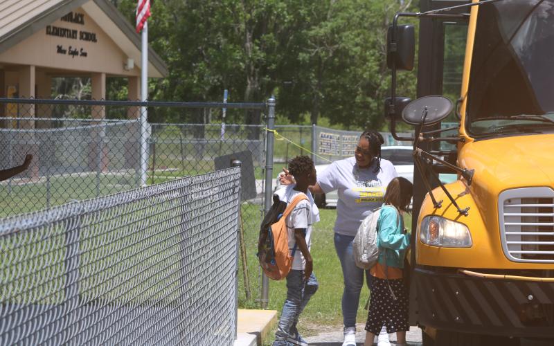 Makeba Murphy, Niblack Elementary School principal, hugs students on the final day of school before they board their buses. The Niblack school building is scheduled to be demolished in a few weeks and a new school building erected on the site. (TONY BRITT/Lake City Reporter)