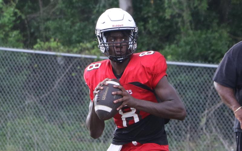 Fort White quarterback Jayden Jackson rolls out to pass during practice on May 1. (MORGAN MCMULLEN/Lake City Reporter)