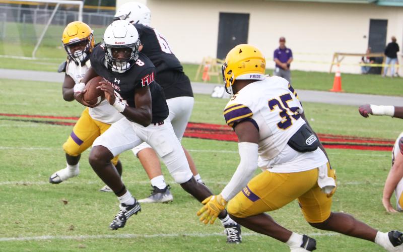 Fort White quarterback Jayden Jackson scrambles up the field as Columbia linebacker Chris Jordan runs in for a tackle during the teams’ spring game on May 17. (MORGAN MCMULLEN/Lake City Reporter)
