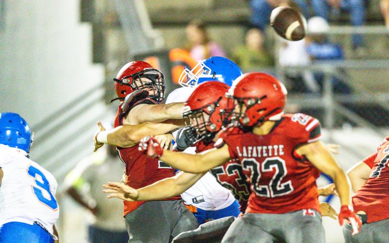 Lafayette quarterback Tucker Higginbothom gets hit by a Taylor County defender after throwing a pass during the teams’ spring game on May 23. (JACK HOWDESHELL/Special to the Reporter)