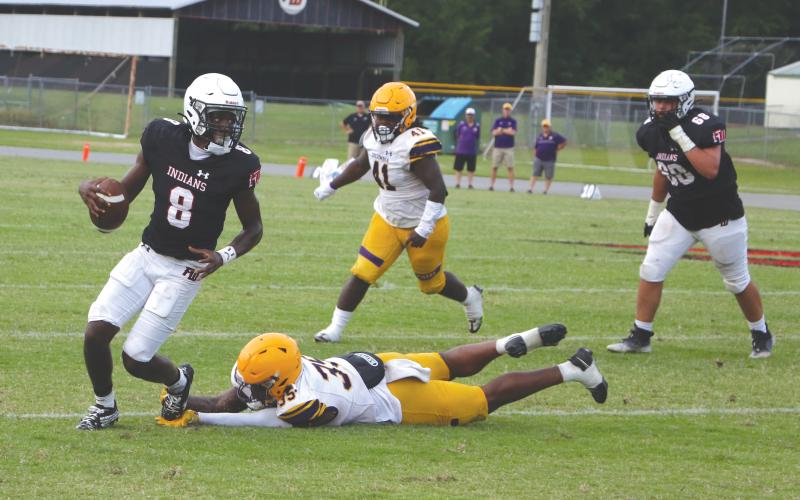 Fort White quarterback Jayden Jackson scrambles away from pressure from Columbia linebacker Chris Jordan during Friday's spring game. (MORGAN MCMULLEN/Lake City Reporter)