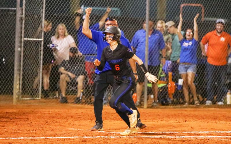 Branford third baseman Madyson Sikes smiles rounding third base as head coach Oscar Saavedra celebrates after she hit a walk-off home run to defeat Fort White in the Region 3-1A championship on May 14. (BRENT KUYKENDALL/Lake City Reporter)