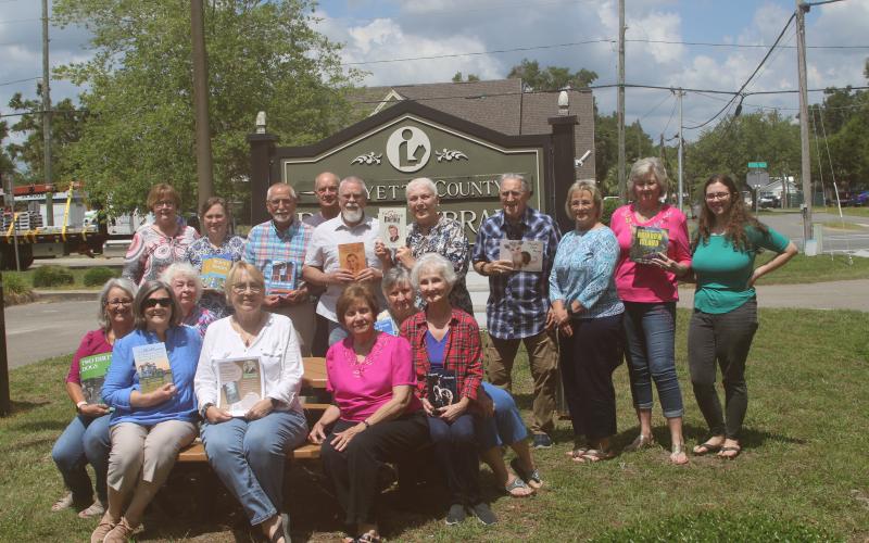 Members of the Writers Ink group at the Lafayette County Public Library hold up their books. The group of authors meet monthly. (JAMIE WACHTER/Lake City Reporter)