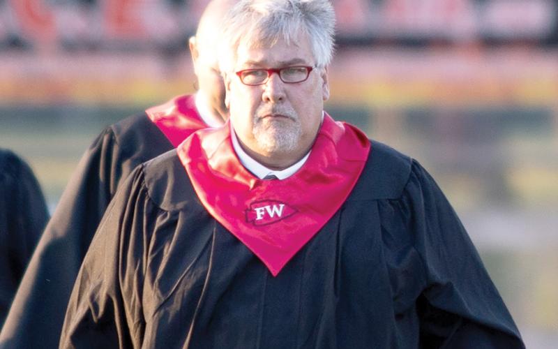Fort White High Principal Keith Couey walks on to the Arrowhead Stadium field last month for graduation. Couey is being moved to the district office as he prepares to be the district superintendent. (RAY CARPENTER/Special to the Reporter)