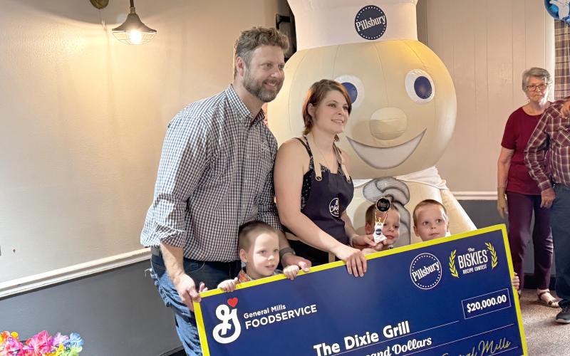 Rebecca and Robbie Thomas, chefs at the Dixie Grill, are joined by their sons, Colby, Carter and Conner, with the $20,000 prize check from winning The Biskies Contest. (JAMIE WACHTER/Lake City Reporter)
