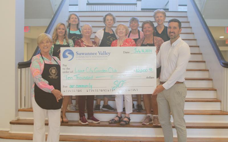 Tina Roberts (front row, from left) stands with other Lake City Garden Club members, as she and Patrick Douglas, of the Suwannee Valley Community Foundation, hold a $10,000 check that was presented to the organization on Wednesday at the Blanche Hotel. Other Garden Club members present include, Ginger McCrannie (second row from left), Cheryl Libert, Kathy Smith and Mary Victores; Jan Logan (back row, from left), Terri Johnson, Sonya Rossin and Dorothy Colvin. (TONY BRITT/Lake City Reporter)