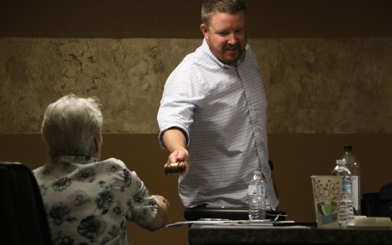Lake Shore Hospital Authority Chair Stephen Douglas passes the gavel to Lori Chancy before a vote on the parking lot deal with the Lake City Masonic Lodge No. 27 during Monday’s meeting. (MORGAN MCMULLEN/Lake City Reporter)