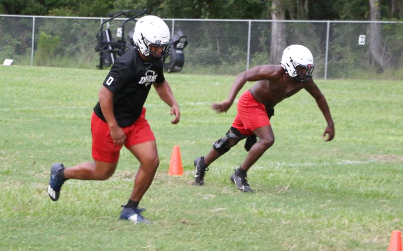 Fort White linebackers Lecosta Byrd (left) and David Harps run drills at Tuesday’s practice before it was called due to lightning and rain. (MORGAN MCMULLEN/Lake City Reporter)