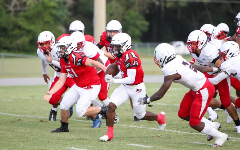 Fort White running back Keimarion Neal bursts through the NFEI defense during Thursday's Preseason Classic. (MORGAN MCMULLEN/Lake City Reporter)