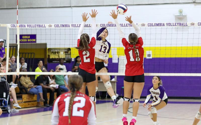 Columbia hitter Kayla Goodloe fires a shot at two Baker County defenders during Thursday's match. (BRENT KUYKENDALL/Lake City Reporter)